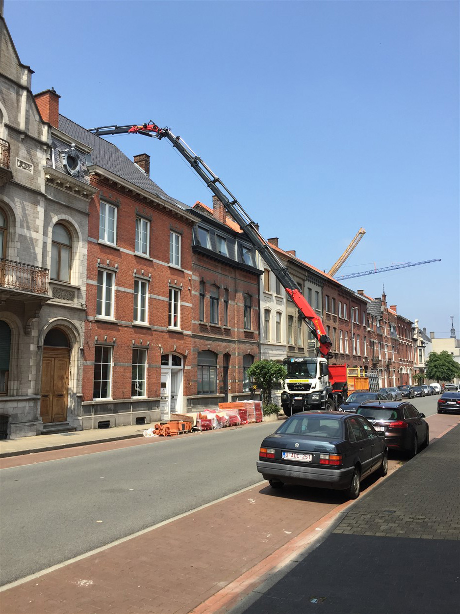 Kraan in actie op een bedrijventerrein met volledig uitgeschoven giek