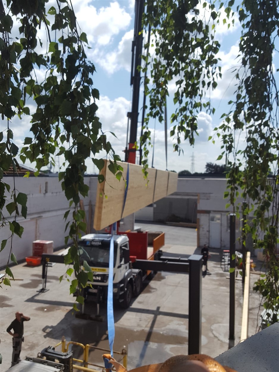Kraan plaatst een groot bouwelement op een structuur in opbouw