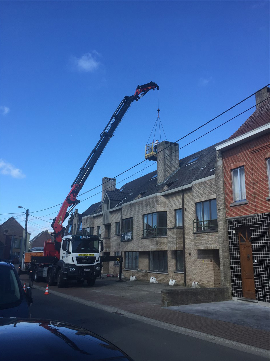 Kraan plaatst een stalen constructie-element op een industrieel gebouw in aanbouw