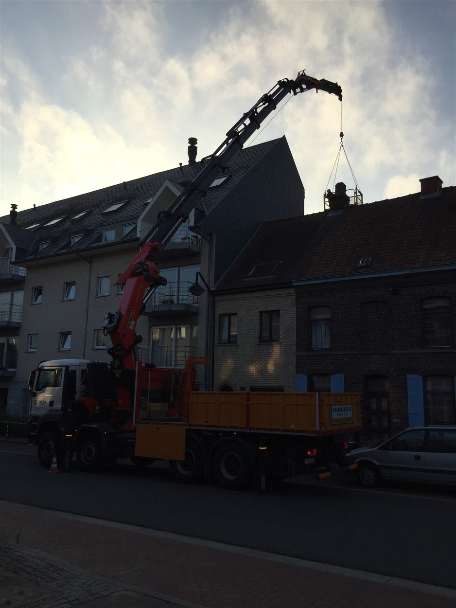 Kraanwagen vervoert en hijst bouwmateriaal op een werf