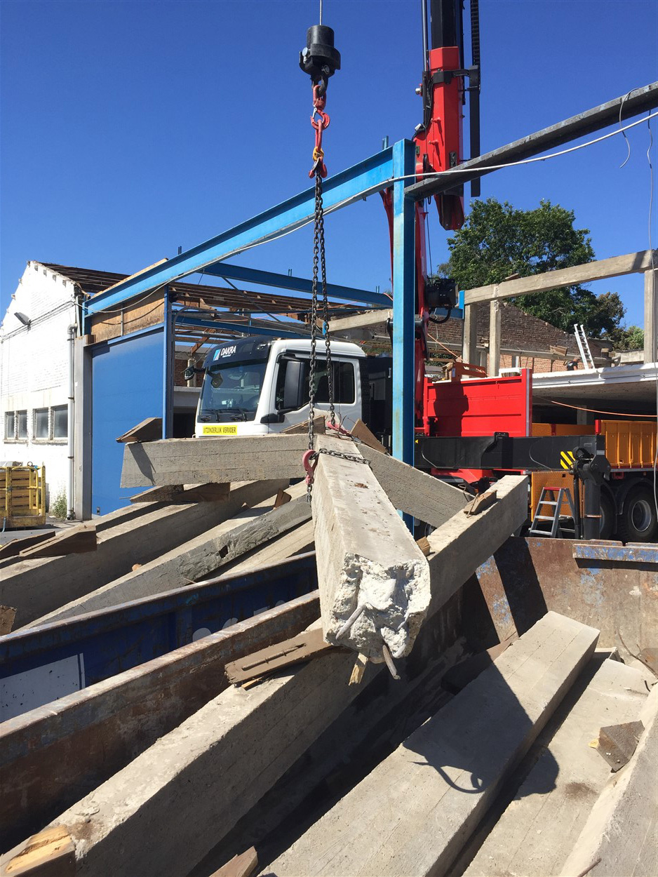 Kraan plaatst betonnen predallen op een ruwbouwconstructie