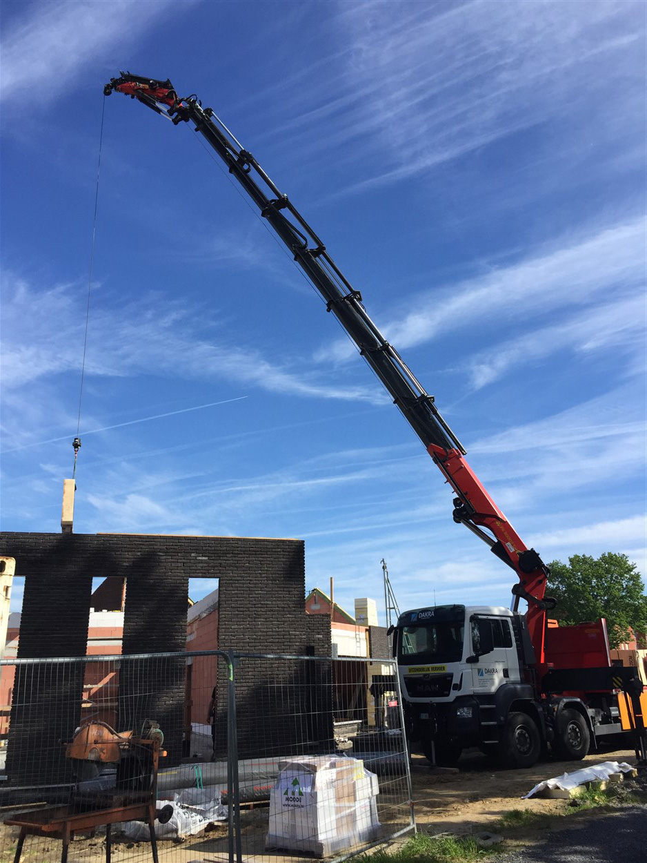 Kraan plaatst betonnen welfsels op een ruwbouwconstructie